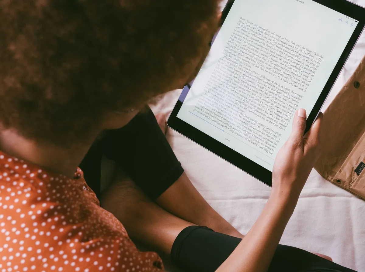 Personne lisant un texte large et bien contrasté sur une tablette, illustrant l'importance de la lisibilité pour un site accessible