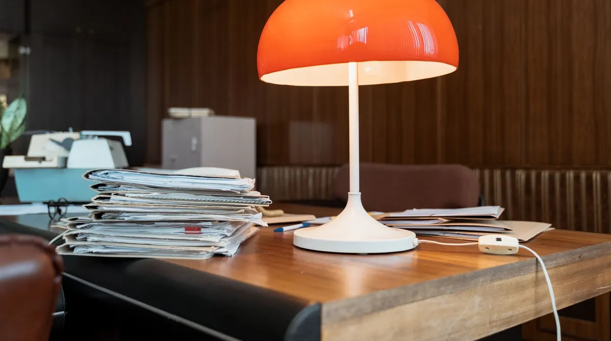 Bureau d'agence fermée avec pile de dossiers et lampe orange, agence web fermée que faire pour le site