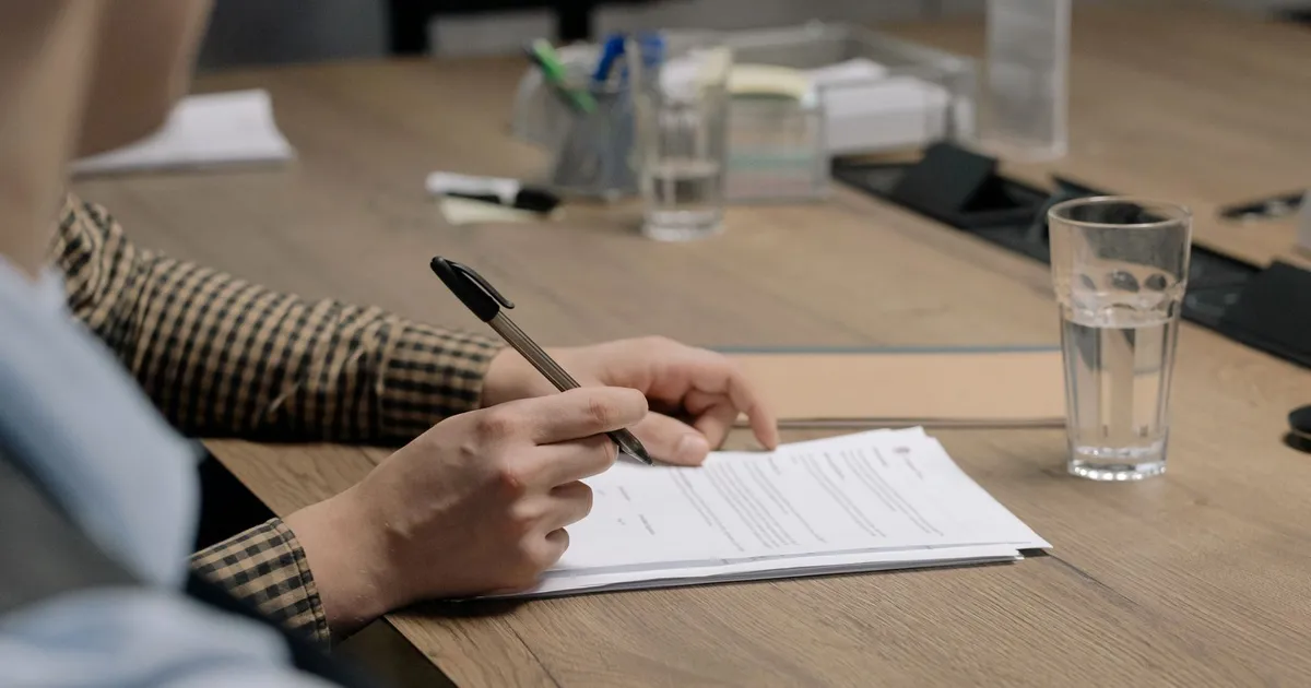 Artisan vérifiant et signant un contrat sur un bureau en bois, agence web Brest