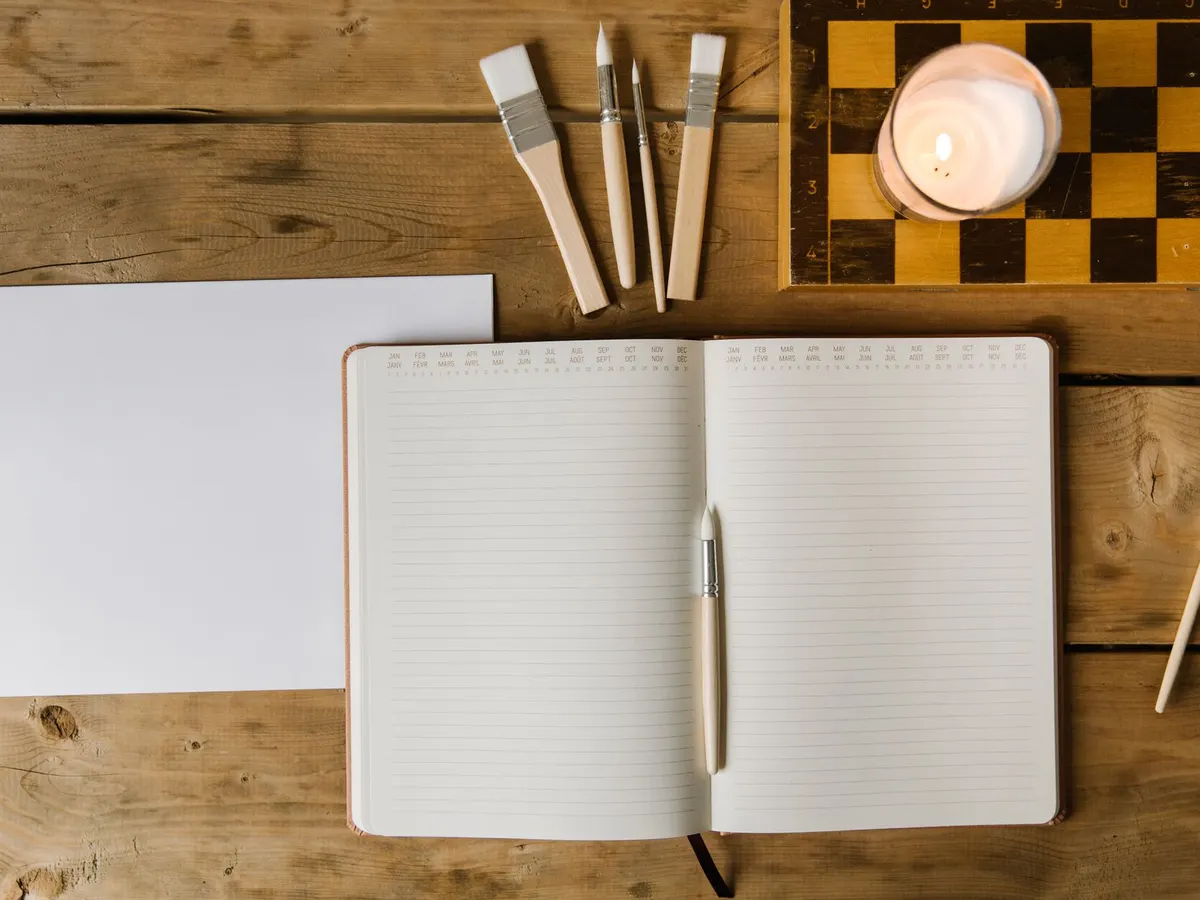 Agenda ouvert sur un bureau en bois, pour planifier le temps mensuel consacré à sa fiche Google
