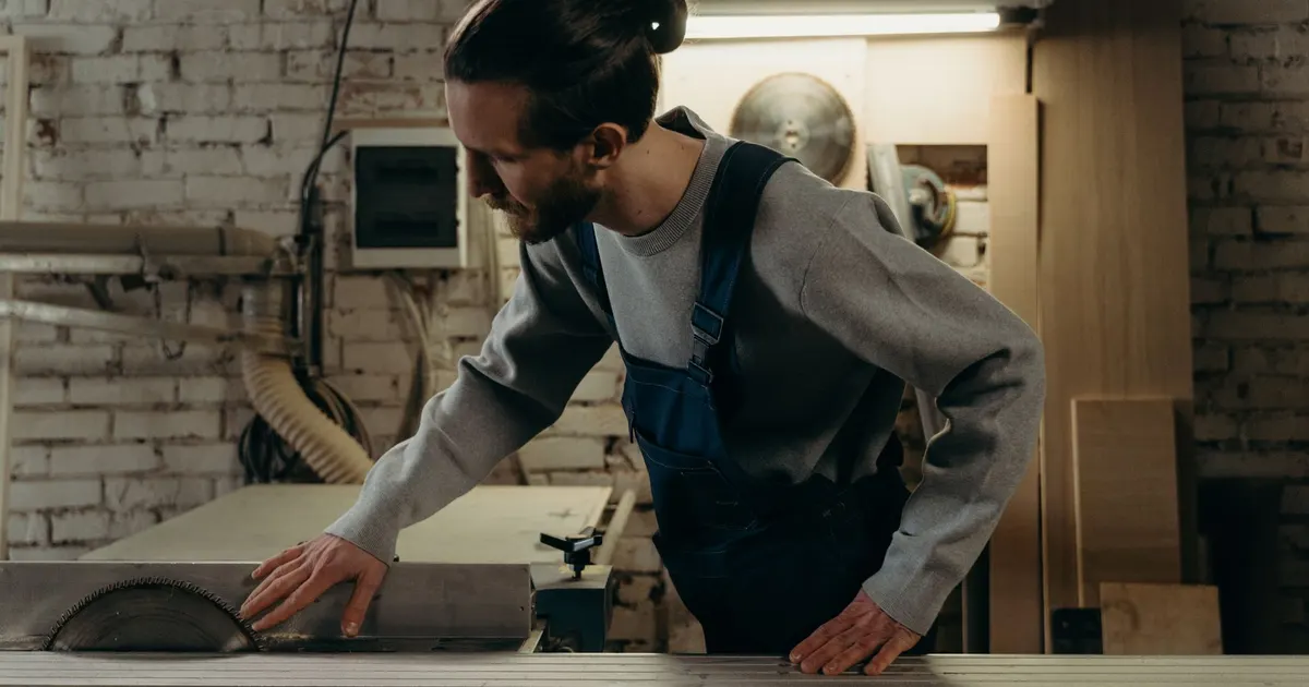 Menuisier de profil à la scie à table dans son atelier, à qui appartient le site internet de l'artisan