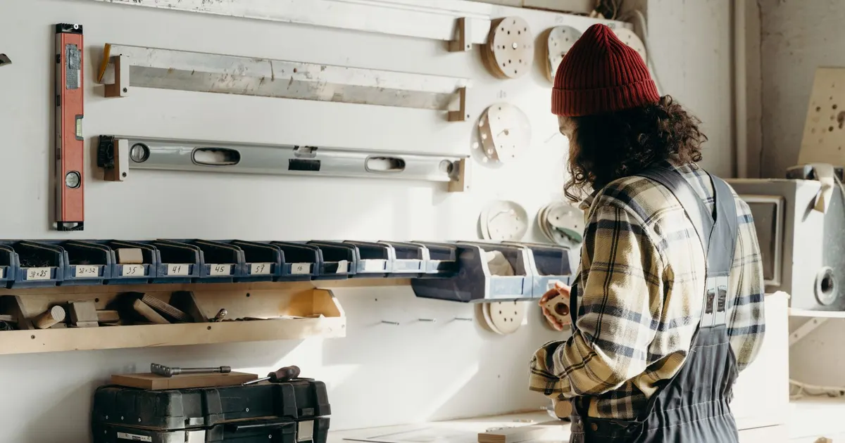 Artisan de dos dans son atelier de menuiserie devant un mur d outils, pour vérifier ce que promet une garantie de première page Google